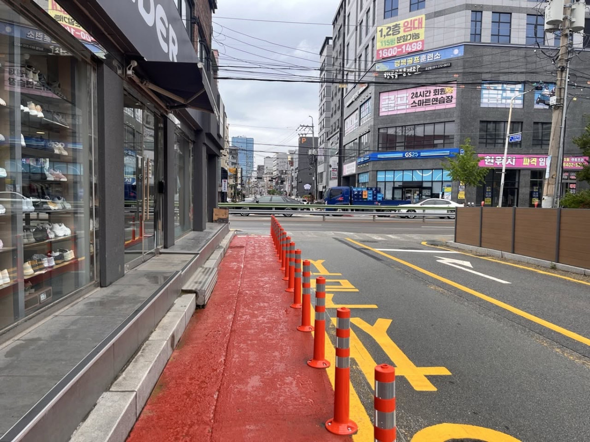 ▲오산시 운암고·운암초 주변 통학로에 보행 공간을 표시한 붉은색 노면 도색과 차도 분리용 안전시설이 설치돼 있다. 조용호 오산시장은 학부모의 SNS 제보를 접수한 뒤 통학로 안전 개선에 나섰으며, 일방통행 전환과 보도 신설 등 추가 대책도 검토하겠다고 밝혔다. (조용호 오산시장 페이스북)