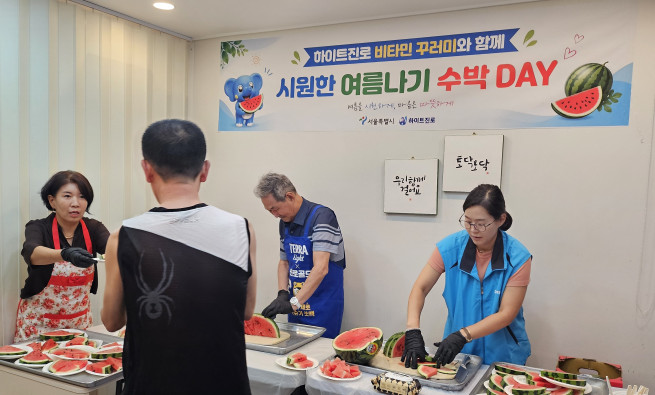▲시원한 여름나기 수박데이 행사장에서 서울역쪽방상담소 및 ㈜하이트진로 관계자와 주민이 함께 나눠먹을 수박을 준비하고 있다. (사진제공=서울시)