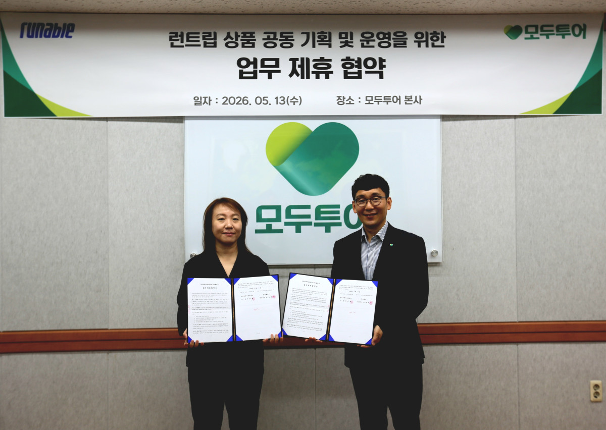 ▲이우연 모두투어 상품본부장(오른쪽)과 신희수 러너블 C&C 사업팀 팀장이 업무협약을 체결하고 기념촬영을 하고 있다. (사진제공=모두투어)