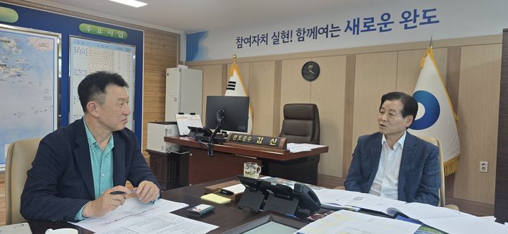 ▲(주)글로벌냉동식품 관계자와 유자 가공공장 건립을 논의하는 김신(오른쪽) 완도군수. (사진제공=완도군)