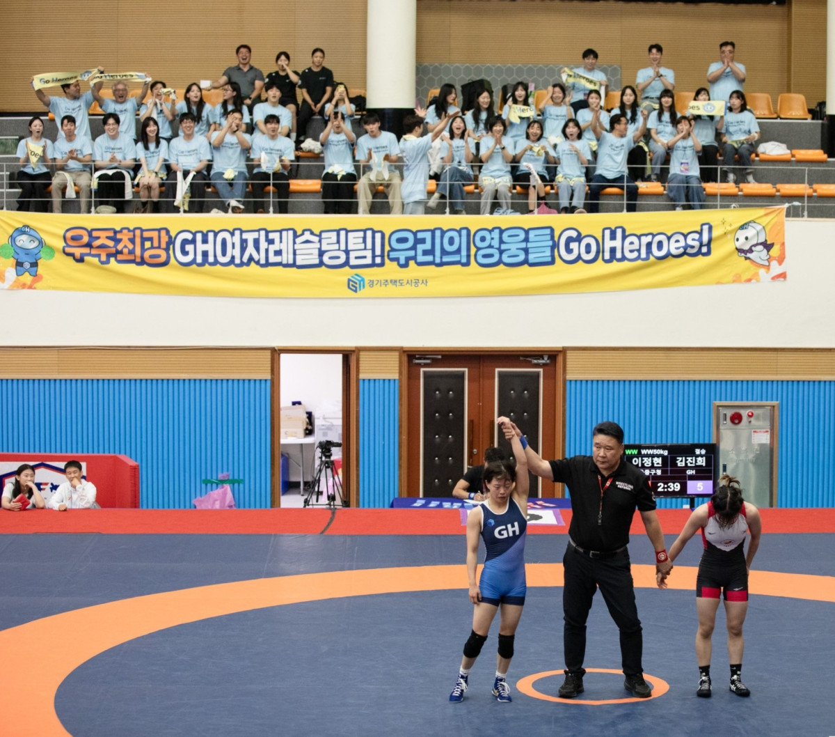▲경기주택도시공사(GH) 여자레슬링팀 주장 김진희 선수가 29일 강원도 양구문화체육회관에서 열린 제52회 대통령기 전국 시도 대항 레슬링대회 여자일반부 자유형 50㎏급 결승에서 역전 폴승을 거둔 뒤 승리 판정을 받고 있다. (경기주택도시공사(GH))