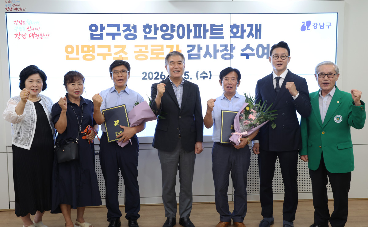 ▲김현기(왼쪽 네 번째) 서울특별시 강남구청장이 5일 강남구청에서 압구정 한양아파트 화재 때 주민 대피를 도운 경비원 김종각(왼쪽 세 번째) 씨와 박한철(오른쪽 세 번째) 씨에게 감사장을 수여한 후 참석자들과 함께 기념 촬영을 하고 있다. (사진 제공 = 서울 강남구)