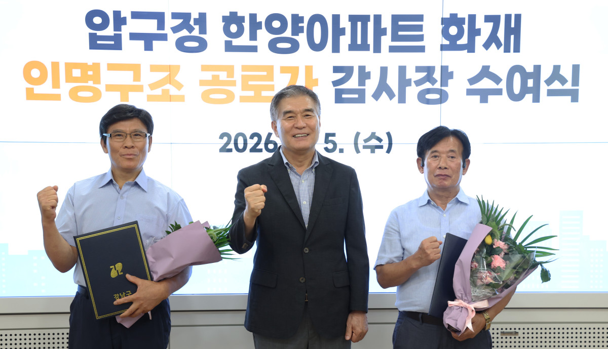 ▲김현기(가운데) 서울특별시 강남구청장이 5일 강남구청에서 압구정 한양아파트 화재 때 주민 대피를 도운 경비원 김종각(왼쪽) 씨와 박한철 씨에게 감사장을 수여한 뒤 기념 촬영을 하고 있다. (사진 제공 = 서울 강남구)