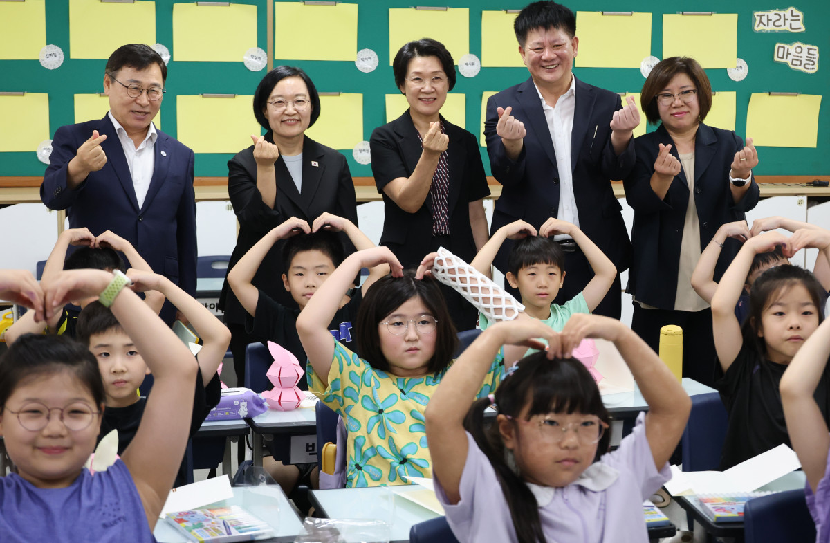 ▲한성숙(뒤에서 왼쪽 두 번째) 국무총리가 방학중 초등돌봄ㆍ교육현장 점검을 위해 7일 서울 영등포구 영문초등학교를 방문해 팝업북 만들기 수업을 참관한 뒤 아이들과 기념 촬영하고 있다. (연합뉴스)