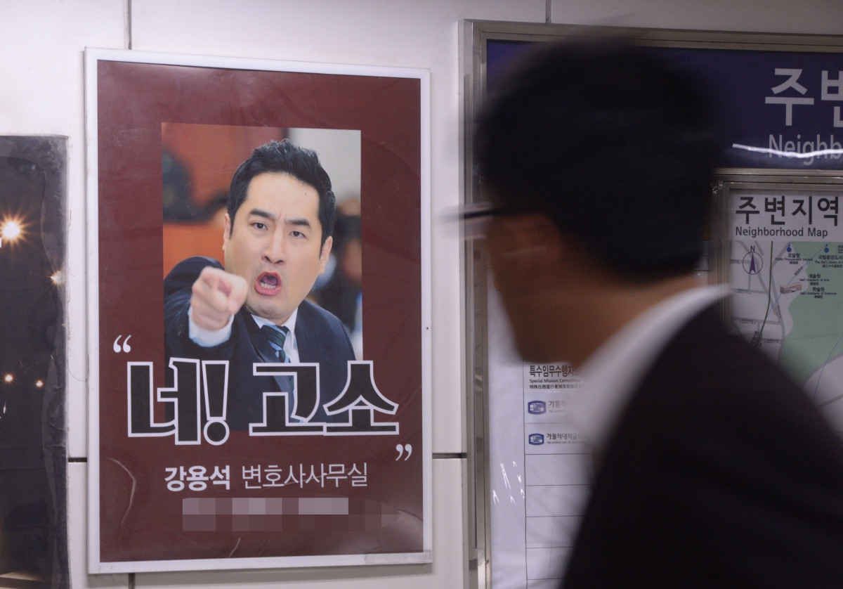 ▲2015년 9월 17일 강용석 변호사 광고 포스터가 게재돼 있는 서울 서초역에 시민들이 포스터를 관심 깊게 바라보며 발길을 재촉하고 있다. (뉴시스)