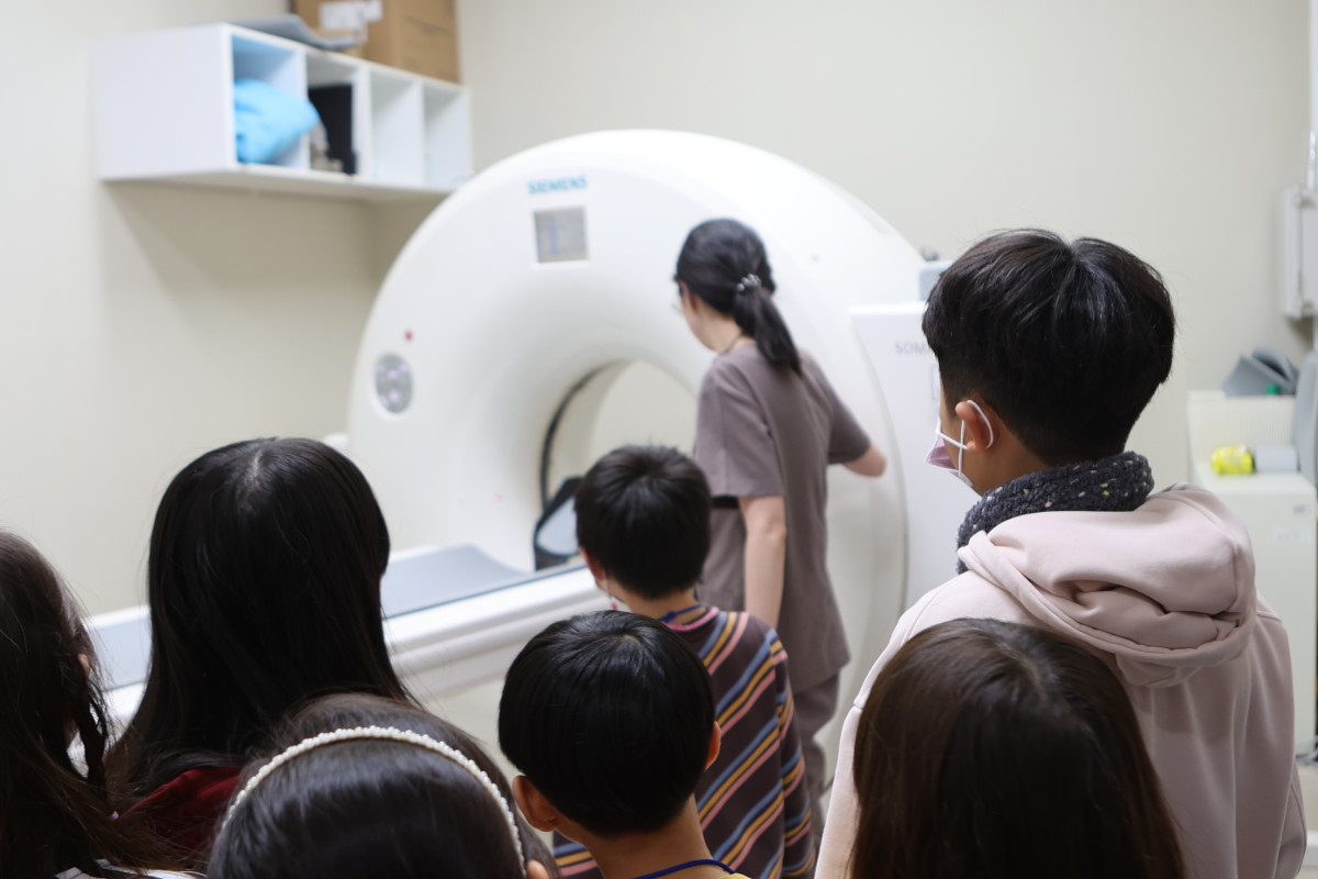 ▲작년 겨울방학에 열린 연세하나병원 '어린이 메디컬 캠프'에서 아이들이 자기공명영상(MRI) 촬영 원리에 대한 설명을 듣고 있다. (연세하나병원)