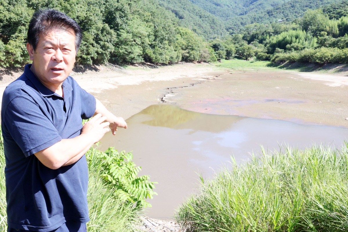 ▲12일 오전 전남광주 곡성군 석곡면 방송리 방송저수지에서 오규섭(65)씨가 메마른 저수지를 가리키고 있다. (연합뉴스)
