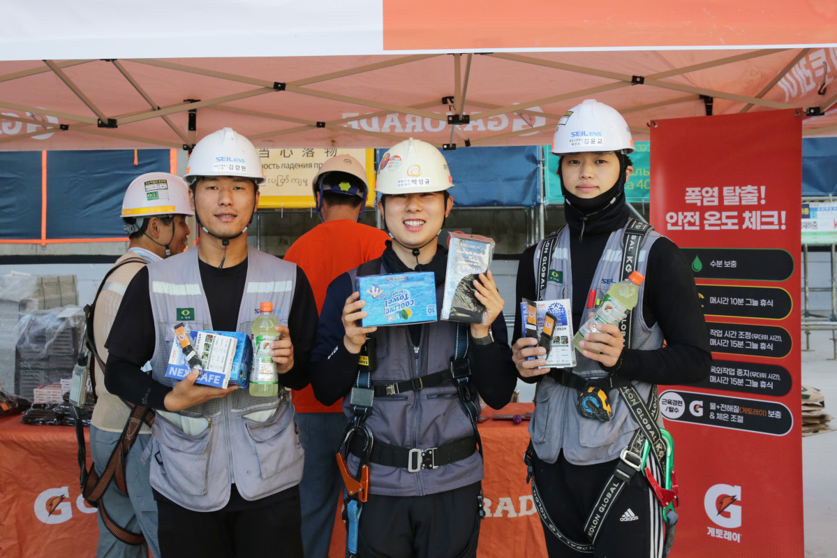 ▲한화 건설부문 근로자들이 온열질환 예방 물품을 전달받고 기념촬영을 하고 있다. (사진제공=한화 건설부문)
