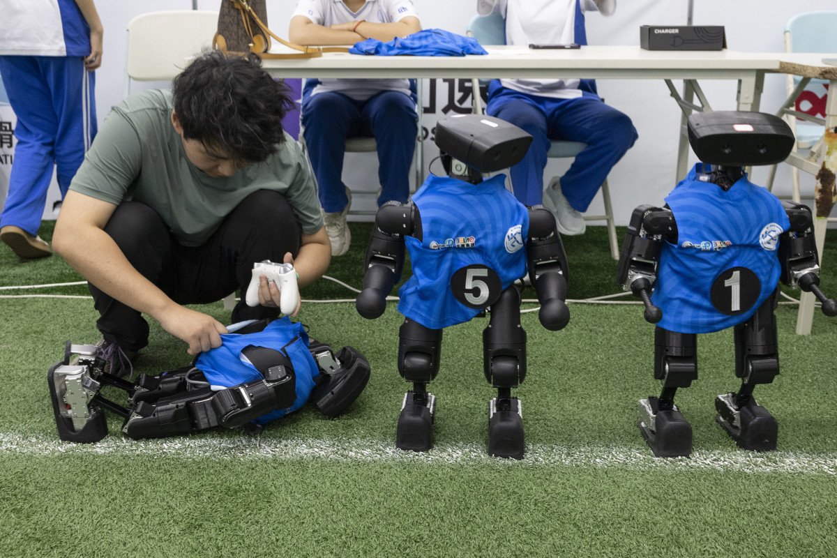 ▲14일 중국 베이징에서 열린 2026 세계 휴머노이드 로봇 운동회 미디어 사전 공개 행사에서 한 팀원이 축구 경기 휴식 시간에 휴머노이드 로봇을 점검하고 있다. 올해로 2회째를 맞은 이 대회는 8월 22일부터 26일까지 개최될 예정이다. 베이징/EPA연합뉴스