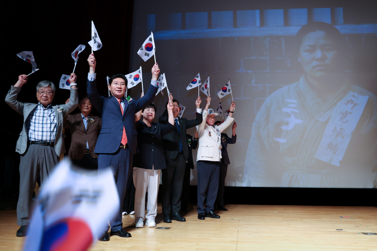▲이상일 용인특례시장(가운데)이 15일 시청 에이스홀에서 열린 제81주년 광복절 경축식에서 독립유공자 유족과 보훈단체 관계자 등 참석자들과 태극기를 흔들며 만세삼창을 하고 있다. (용인특례시)