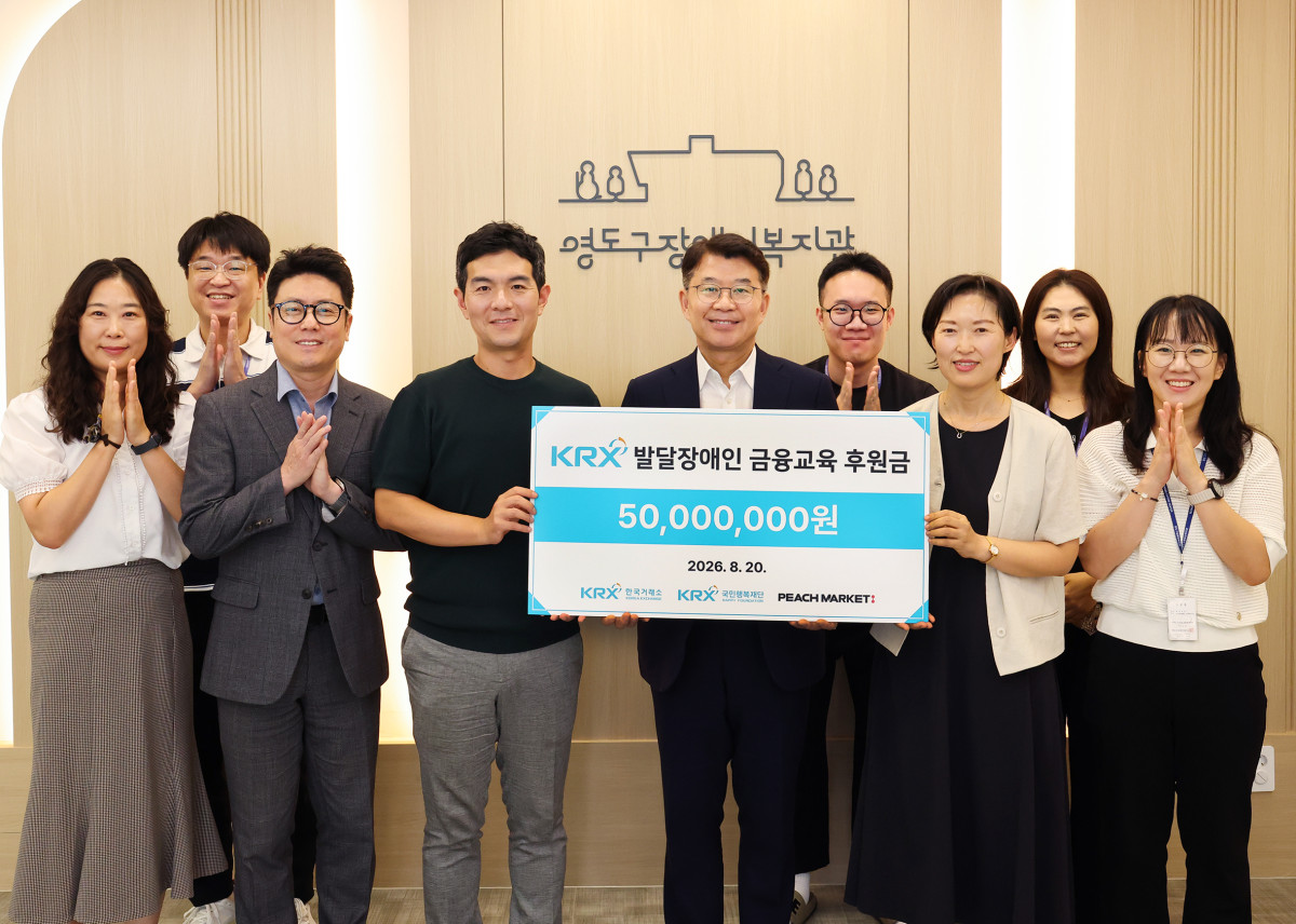 ▲KRX국민행복재단 정상호 사무국장(전달보드 기준 중간), 피치마켓 함의영 대표(전달보드 기준 왼쪽), 영도구장애인복지관 박기영 관장(전달보드 기준 오른쪽) 등 관계자들이 20일(목) 부산지역 발달장애인의 경제적 자립역량 강화를 위한 후원금 전달식 단체 기념촬영을 하고 있다. (사진=한국거래소)