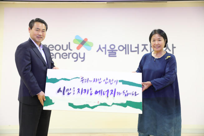 ▲황보연(왼쪽) 서울에너지공사 사장이 손글씨 명장 손영희 작가가 안전기원 액자 전달식 후 기념촬영을 하고 있다. (사진제공=서울에너지공사)