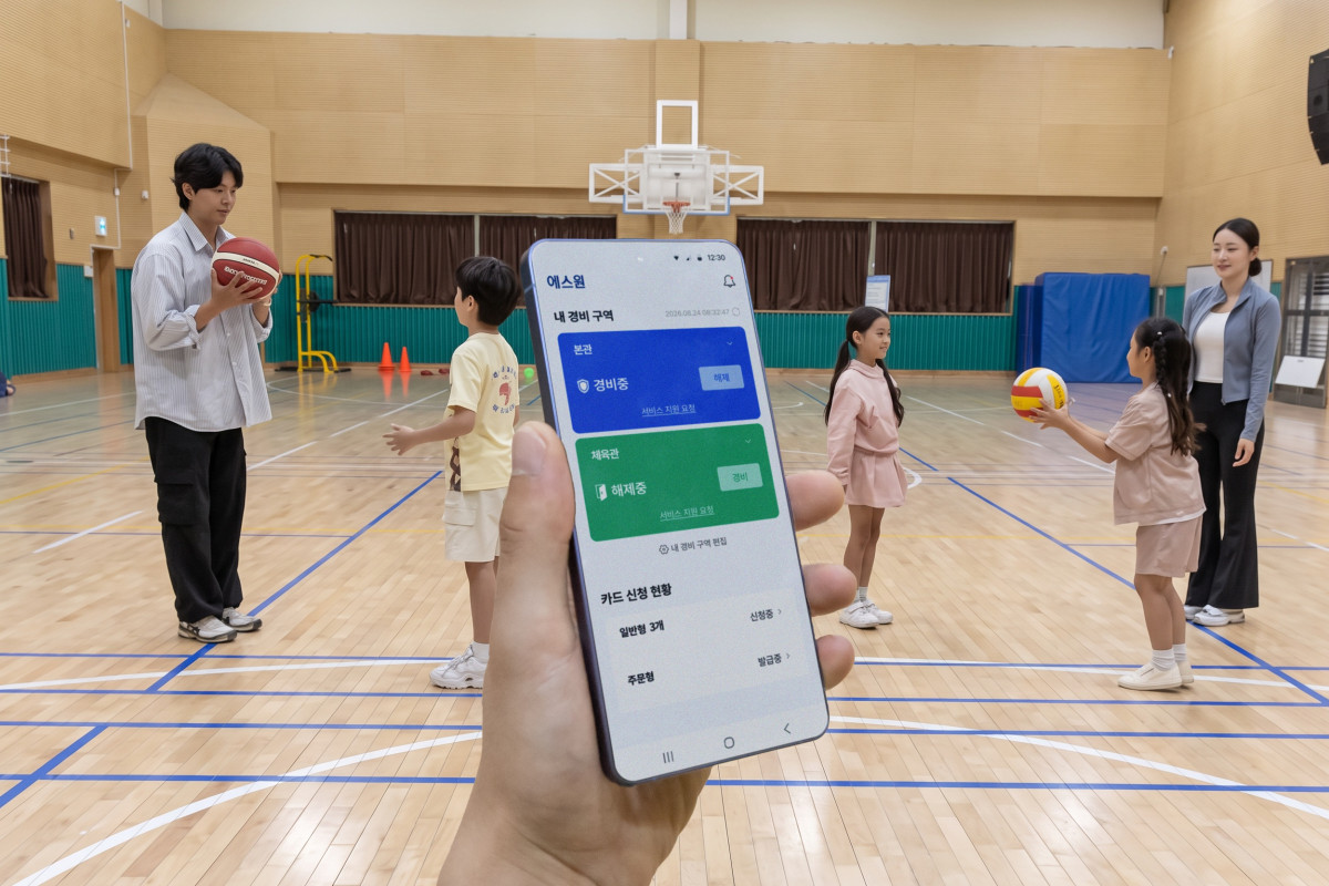▲에스원 학교 안전 솔루션이 적용된 체육관 내부 상황을 모바일 앱으로 모니터링하고 있다. (사진제공=에스원)
