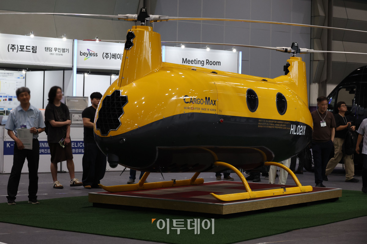 ▲25일 서울 강남구 삼성동 코엑스에서 열린 2026 퓨처모빌리티위크에서 관람객이 월드콥터(WORLDCOPTER)의 자동차 엔진을 탑재한 로봇헬기 카코맥스(CARGO-MAX)를 살펴보고 있다. 이번 행사는 EV트렌드코리아 2026, 2026 자율주행모빌리티산업전(AME 2026), 무인이동체X민군협력엑스포가 27일까지 동시에 열리며 완성차와 배터리, 충전 인프라부터 인공지능(AI), 소프트웨어 정의 차량(SDV), 로보택시까지 미래 모빌리티 생태계 전반의 혁신 기술을 한자리에서 선보인다. 고이란 기자 photoeran@