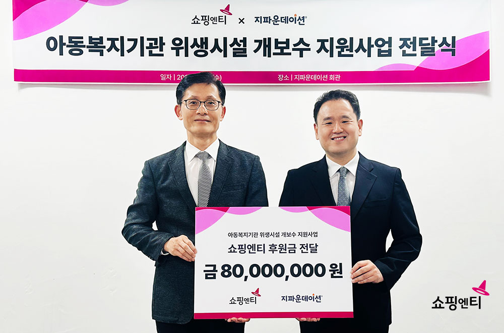 ▲26일 한상욱(왼쪽) 쇼핑엔티 대표이사가 박충관 지파운데이션 대표이사에게 기부금을 전달한 뒤 기념사진을 찍고 있다. (사진제공=쇼핑엔티)