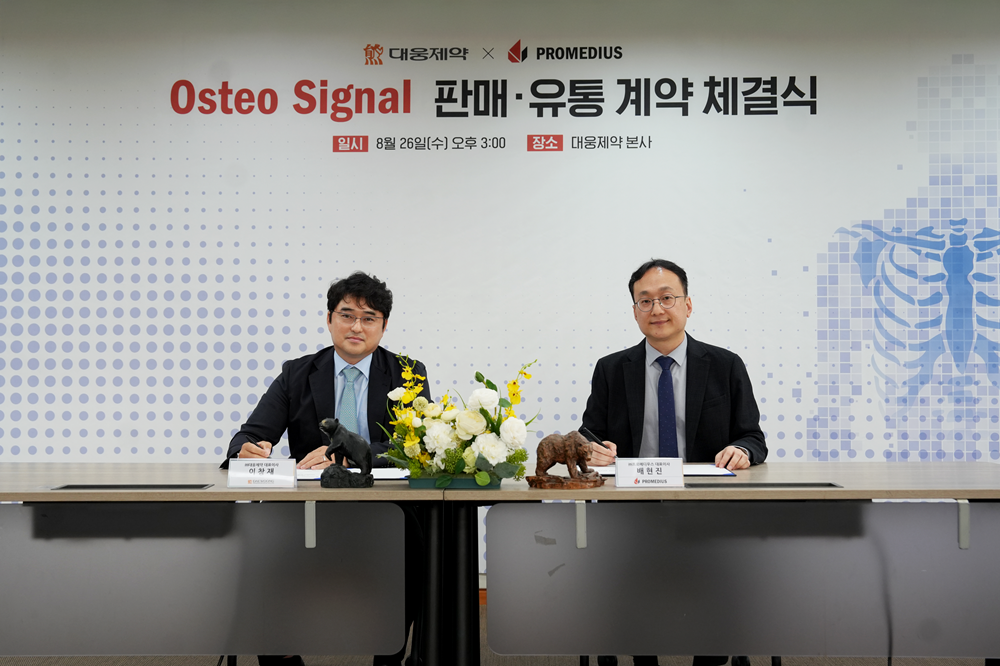 ▲이창재 대웅제약 대표(왼쪽)와 배현진 프로메디우스 대표(오른쪽)가 계약서에 서명을 하고 있다.(대웅제약)