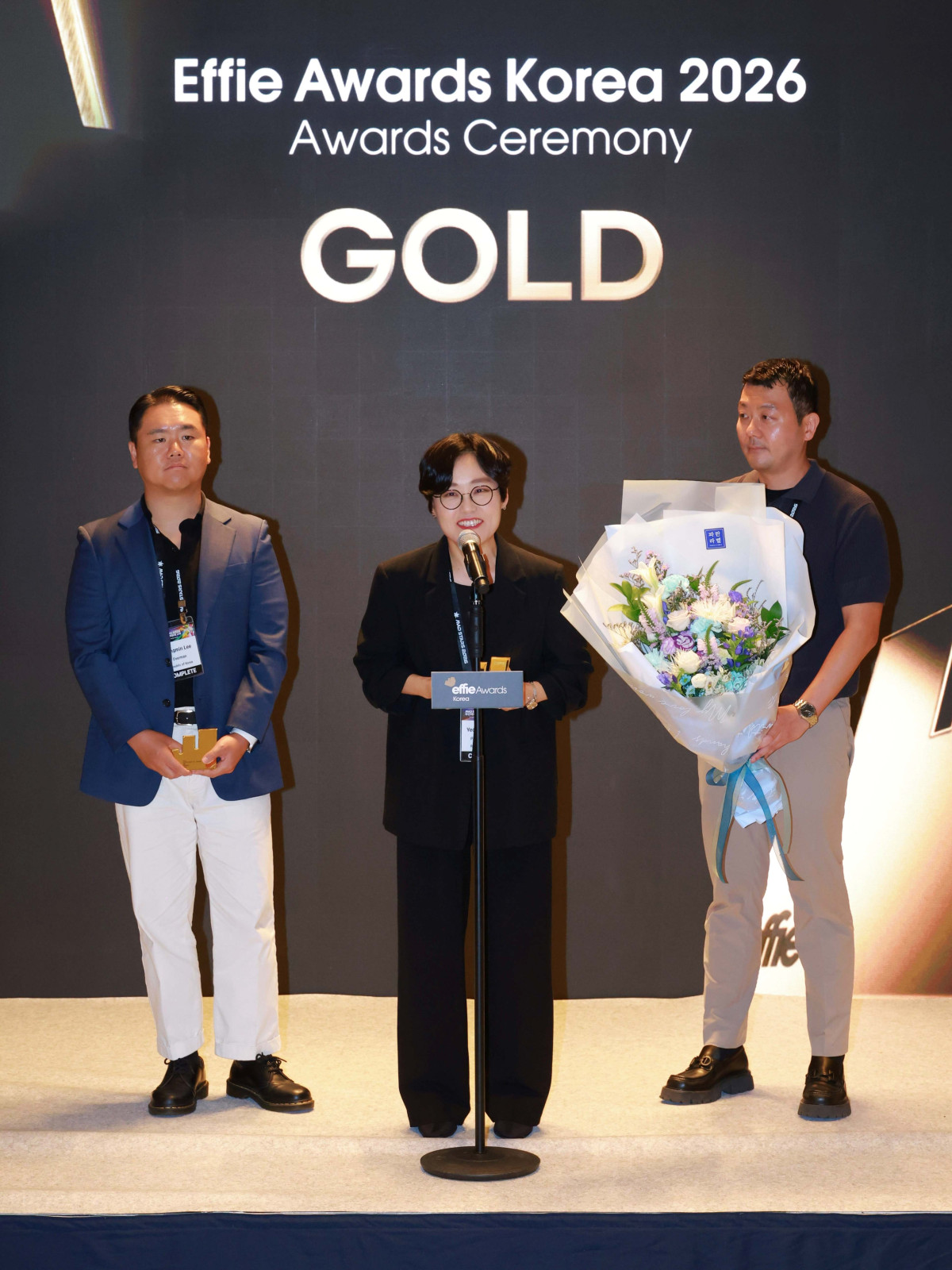 ▲파리바게뜨 마케팅본부장 김연정 상무(가운데)가 ‘2026 에피 어워드 코리아(Effie_Awards_Korea)’에서 금상을 수상하고 있다. (사진제공=파리바게뜨)