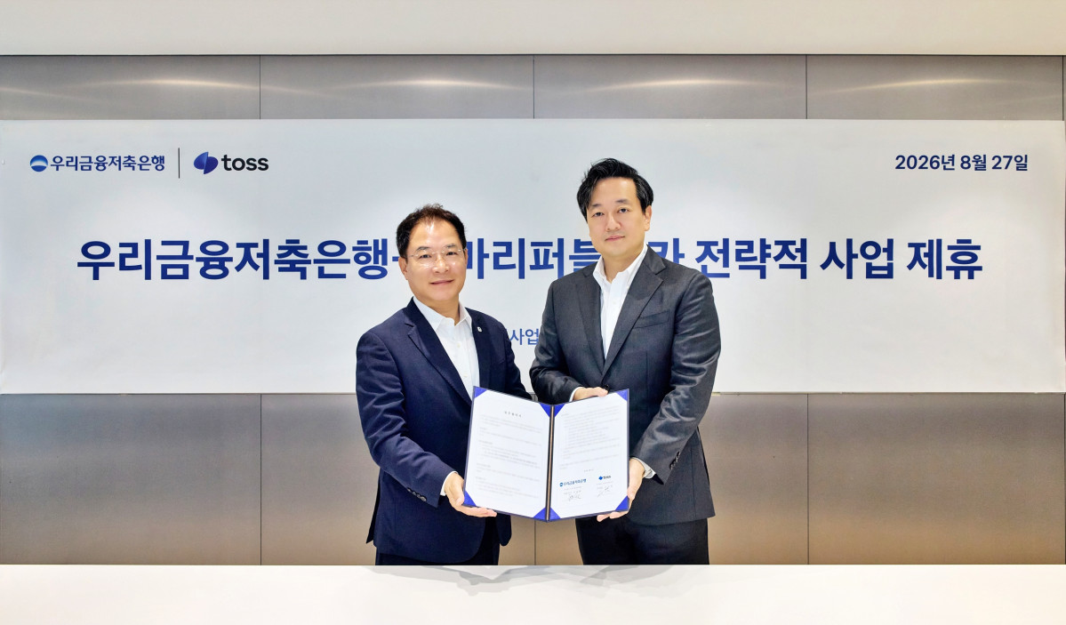 ▲이석태 우리금융저축은행 대표이사(왼쪽) 와 김규하 토스 부대표가 업무협약을 맺고 기념촬영을 하고 있다. (우리금융)