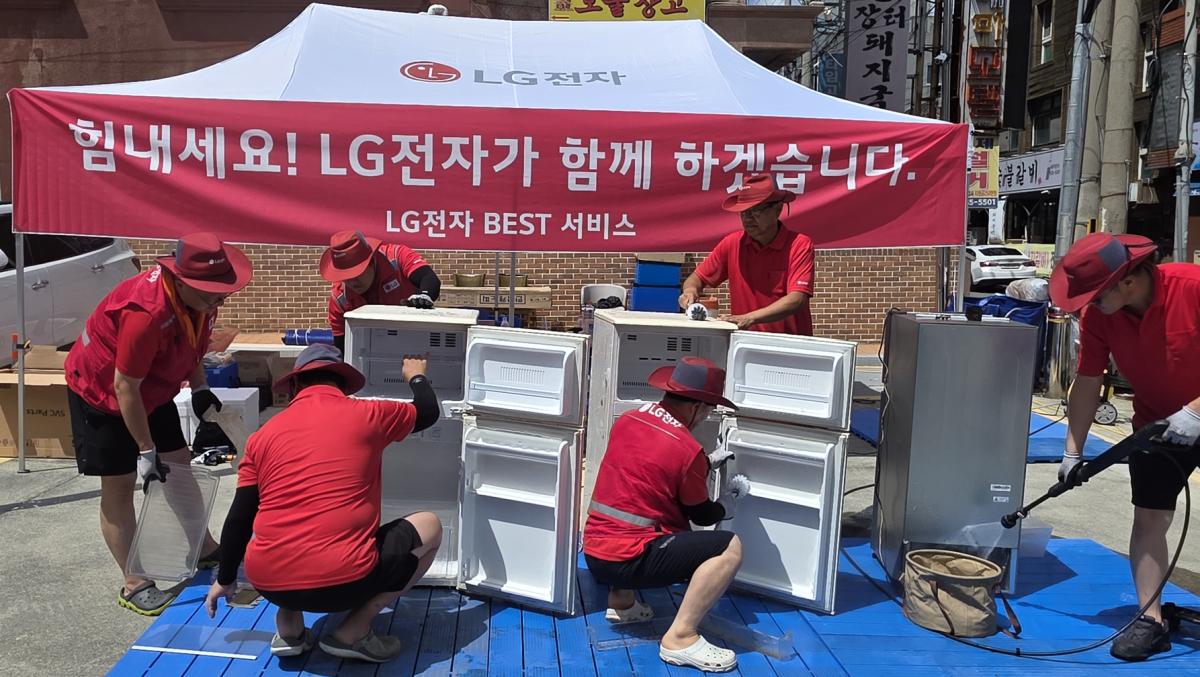 ▲LG전자 서비스 매니저들이 경상남도 거제시 고현동에 마련된 특별 수해 서비스 거점에서 침수 피해를 입은 제품을 점검 및 수리하는 모습 (사진제공=LG)
