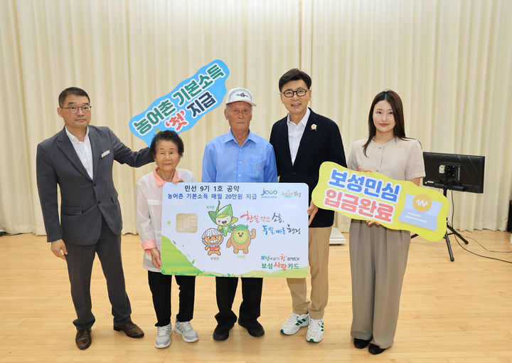 ▲김철우(오른쪽에서 두번째) 보성군수가 최근 겸백면민의 날 행사장에서 농어촌 기본소득 첫 지급을 기념해 지역 장수 노인 부부에게 보성사랑상품권 카드 모형을 전달하고 있다. (보성군)