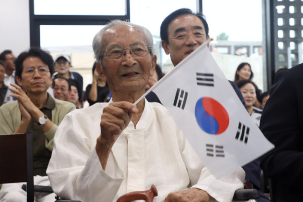 ▲‘광복잇길’ 행사에 참석한 강태선 애국지사가 태극기를 흔들고 있다.(자생한방병원)