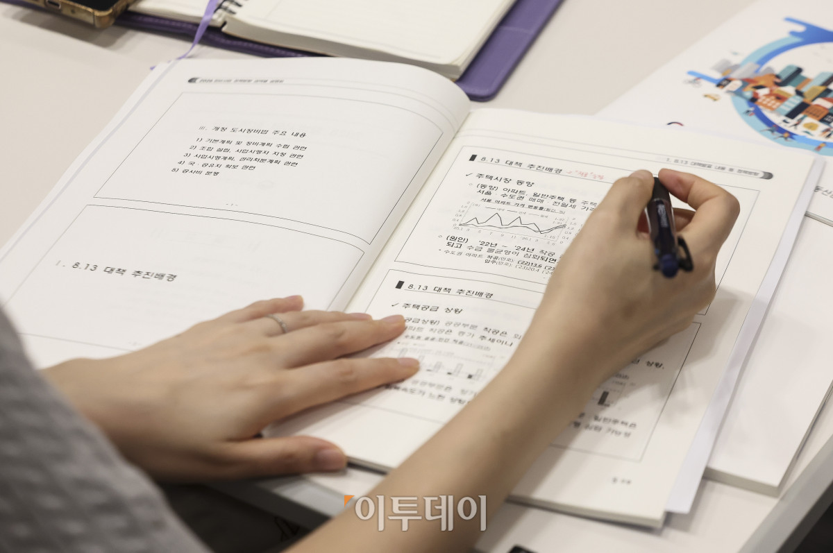 ▲1일 서울 중구 연세대학교세브란스빌딩 회의실에서 '2026 정비사업 정책방향 권역별 설명회'에서 참석자가 안내 책자를 살펴보고 있다. 이날 열린 설명회는 지난 13일 정부가 발표한 '주택 신속공급 방안'에 담긴 정비사업 정책 방향과 제도 개선 내용을 사업 이해관계자들에게 전달하기 위해 마련됐다. 주택도시보증공사(HUG)와 한국토지주택공사(LH), 한국부동산원도 참여해 이주비 대출 등 금융지원과 공공재개발 사업, 공사비 검증 등 정비사업 지원 제도와 관련해 설명한다. 고성준 기자 joonko1@