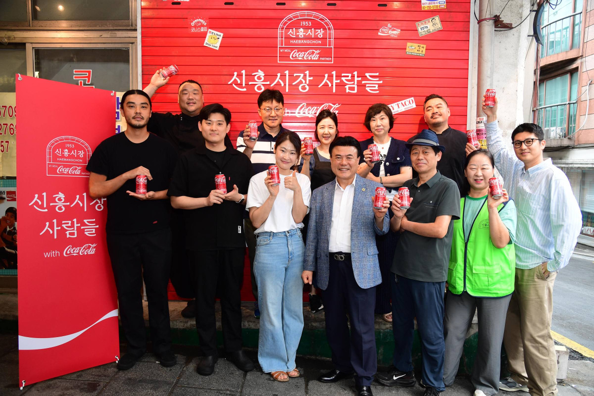 ▲<신흥시장 사람들 with 코카-콜라> 전시에 함께한 신흥시장 상인들이 기념사진을 촬영하고 있다. (사진제공=코카-콜라)