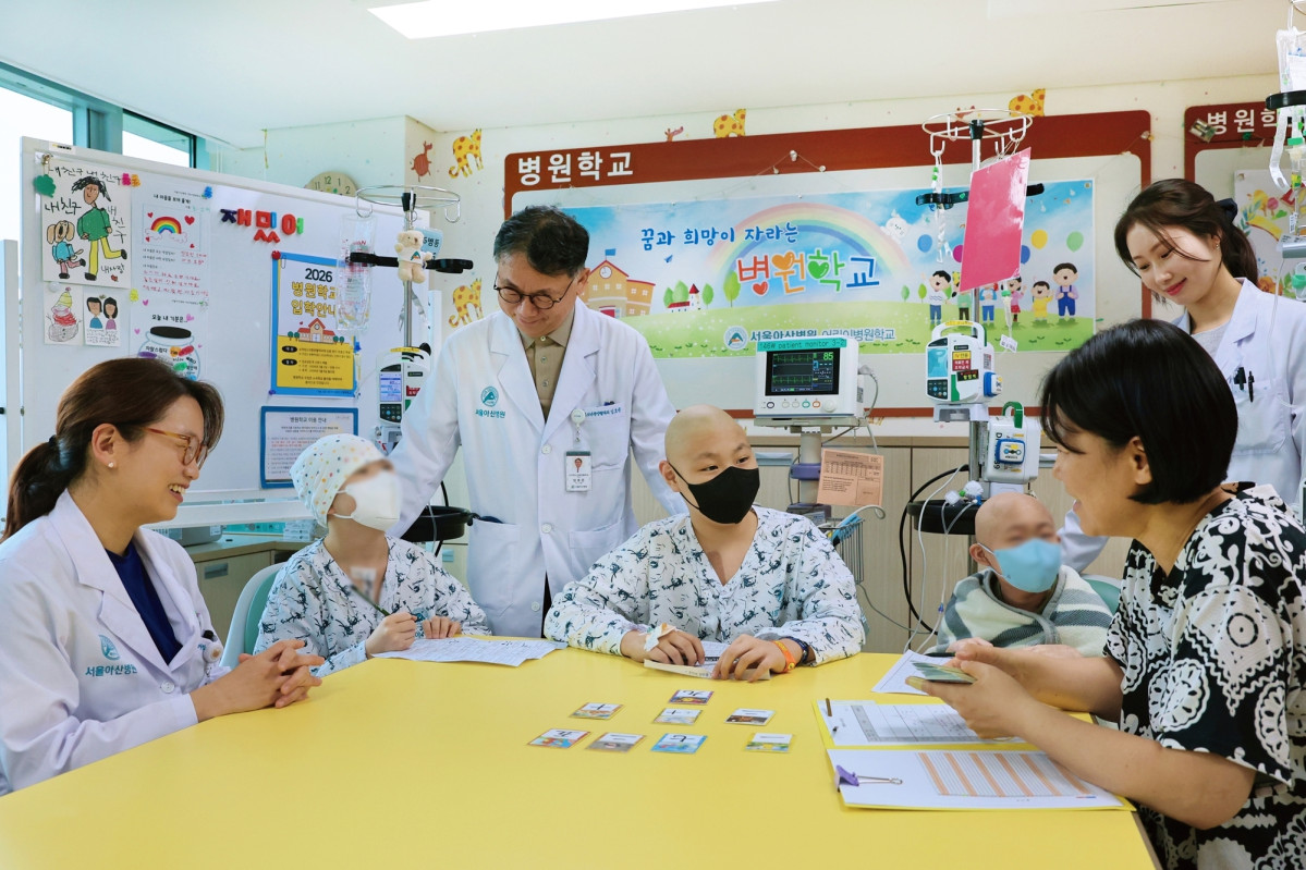 ▲서울아산병원 어린이병원학교에서 김혜리 어린이병원학교장, 임호준 어린이병원장(왼쪽 첫 번째, 세 번째)이 자원봉사자 이은정 교사에게 한문수업을 듣고있는 소아암 환아들을 격려하고 있다. (사진제공=서울아산병원)