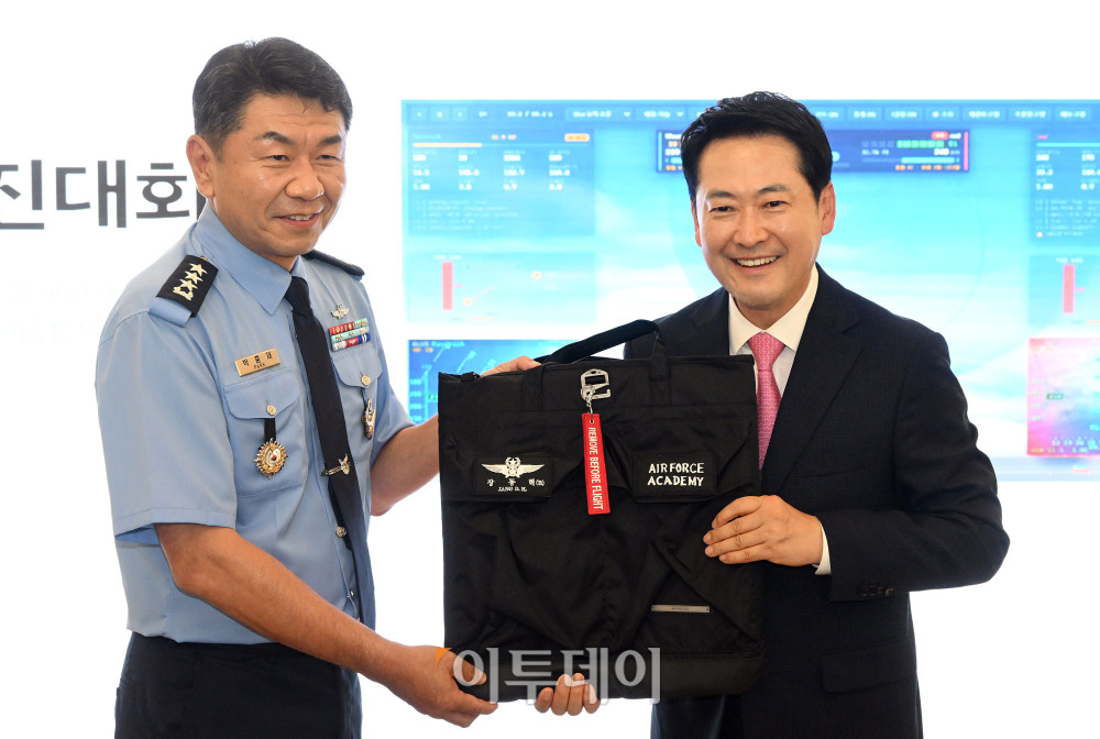 ▲장동혁(오른쪽) 국민의힘 대표가 7일 충북 청주시 상당구 공군사관학교를 방문해 AI 파일럿 매치 시뮬레이션 시연을 본 뒤 박흥재 공군사관학교장에게 방문 기념 헬멧백을 건네받고 있다. 국회사진기자단