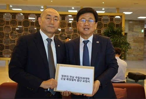 ▲김원이(왼쪽) 더불어민주당 의원이 최근 국회에서 최교진 교육부 장관에게 '국립의과대학 신설 확정절차 중단 요청서'를 전달하고 있다. (김원이 국회의원실)