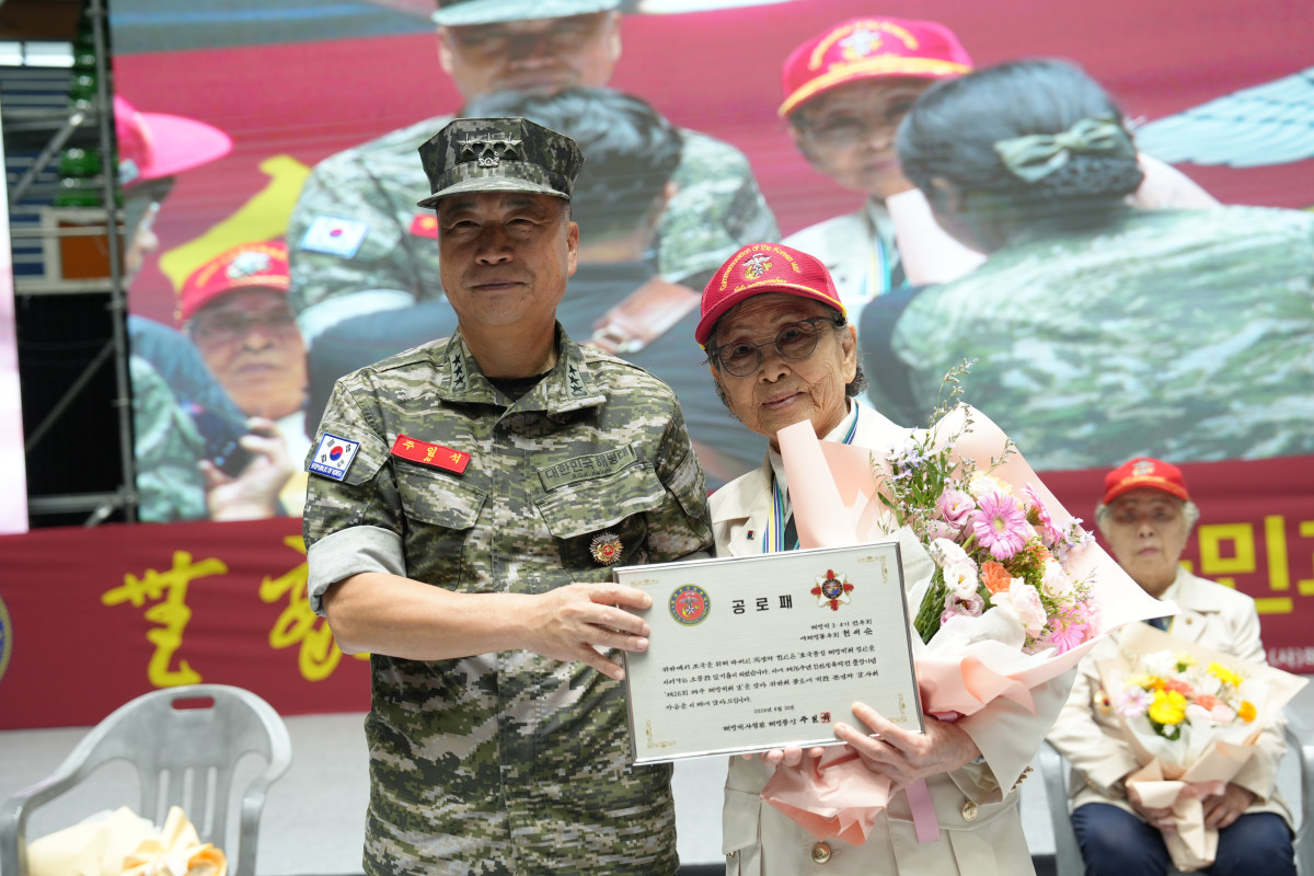 ▲2026년 8월 30일 제주도 한라체육관에서 개최된 제26회 제주 해병대의 날 기념식에서 주일석 해병대사령관이 현애순 참전용사(해병 4기)에게 공로패를 전달하고 있다. (해병대)