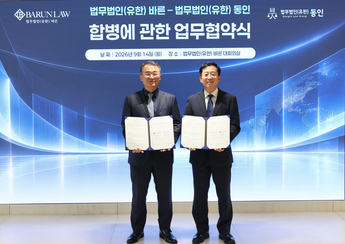 ▲이동훈 바른 대표변호사(오른쪽)와 원창연 동인 대표변호사가 합병추진 업무협약서를 들고 기념사진을 찍고 있다. (법무법인 바른 제공)