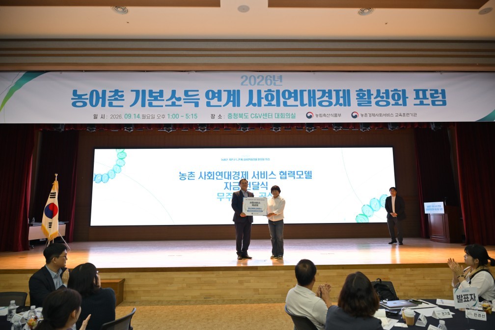 ▲전한영 농림축산식품부 농촌정책국장(왼쪽)이 14일 충북 청주시 충청북도C&V센터에서 '농어촌 기본소득 연계 사회연대경제 활성화 포럼'을 열고 활성화 자금을 전달하고 있다. (사진제공=농림축산식품부)