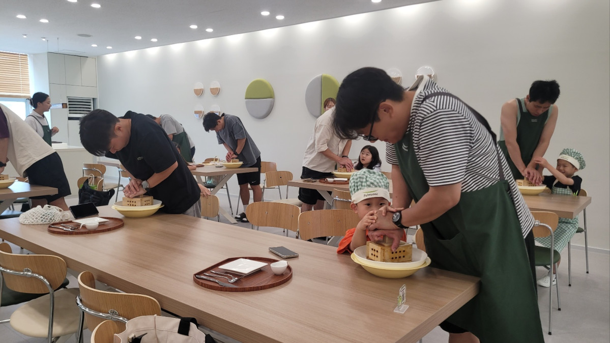 ▲풀무원 음성 두부공장에서 '충북아빠 가치자람단'의 아빠들이 아이와 함께 두부 만들기를 하고 있다. (사진제공=풀무원)