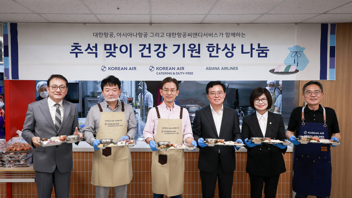 ▲대한항공, 아시아나항공, 대한항공씨앤디서비스 임직원들이 추석맞이 배식 봉사활동에 참여한 뒤 기념사진을 촬영하고 있다. (사진=대한항공)