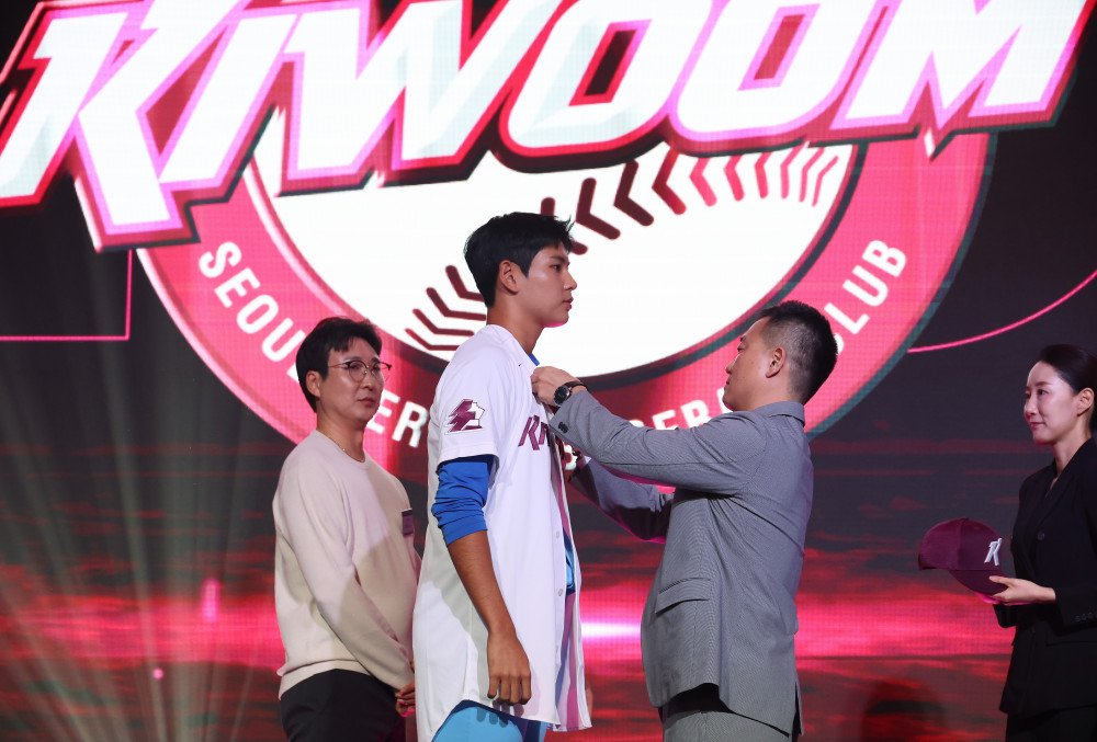 ▲21일 서울 롯데호텔 월드에서 열린 2027 KBO 신인 드래프트. 전체 1순위로 키움 히어로즈의 지명을 받은 부산고 하현승이 유니폼을 받아 입고 있다. (연합뉴스)