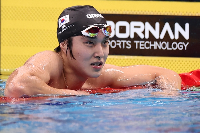 ▲22일 도쿄 아쿠아틱스 센터에서 열린 2026 아이치·나고야 아시안게임 수영 남자 1500m 자유형 결승. 한국 김우민이 결과를 확인한 뒤 경기장을 나서고 있다. 대회를 준비하는 과정에서 왼쪽 어깨 회전근개와 관절와순이 부분 파열된 김우민은 이 사실을 외부에 알리지 않고 물살을 갈랐다. (연합뉴스)