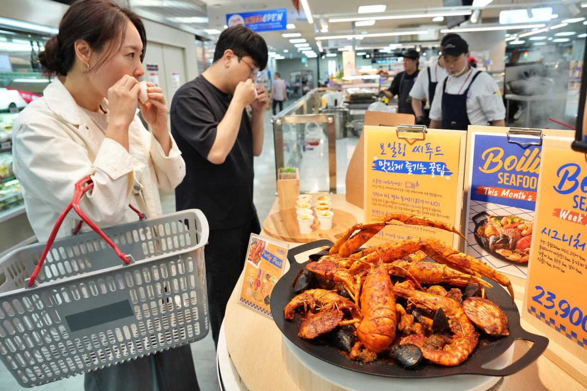 ▲서울시 송파구에 위치한 롯데마트 제타플렉스 잠실점 '파일럿 키친'에서 '보일링 씨푸드'를 시식하고 있는 모습 (사진제공=롯데마트)