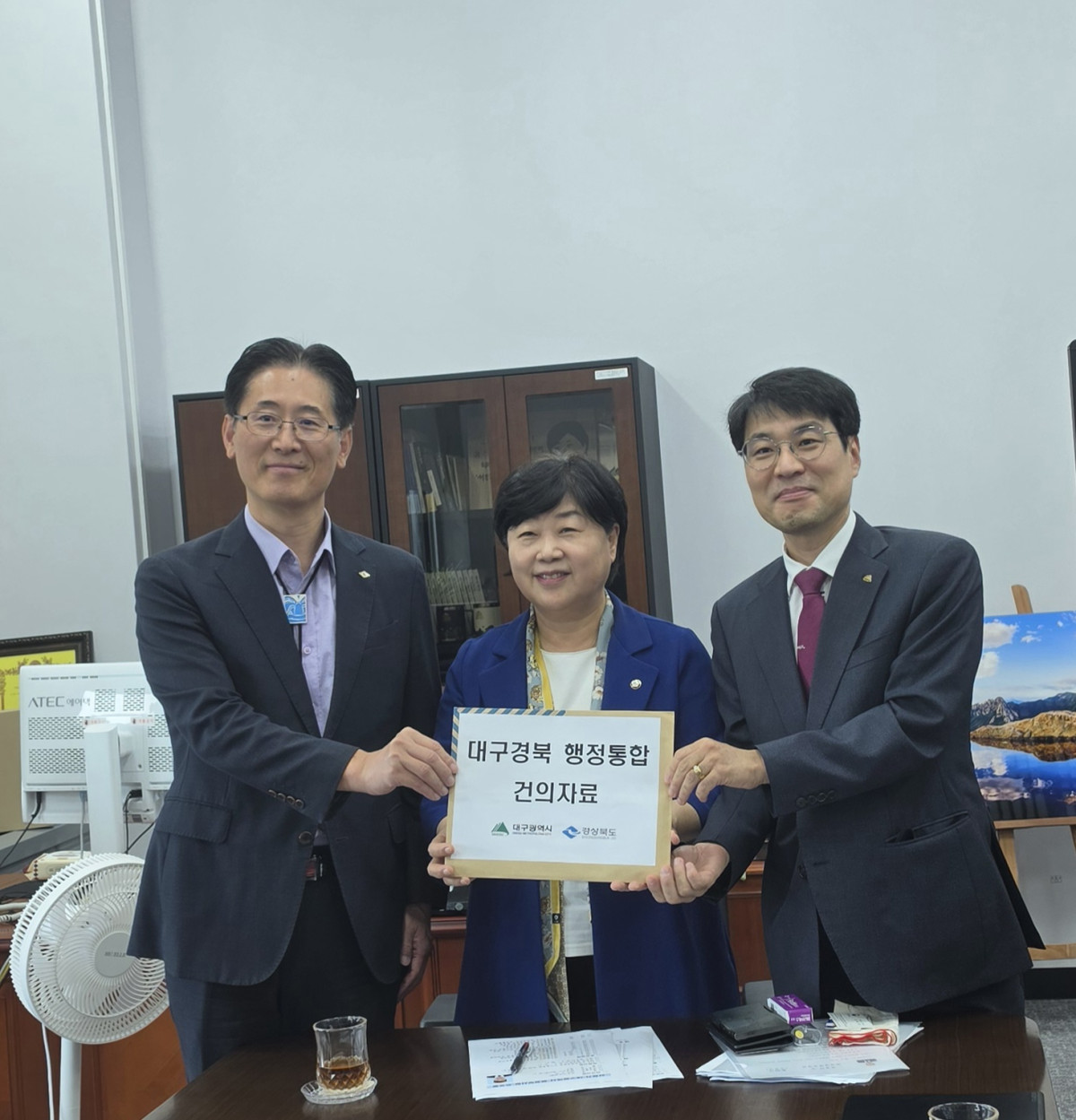 ▲황명석(왼쪽부터) 경북도부지사, 서영교 법사위원장, 김정기 대구시부시장이 30일 국회에서 행정통합 건의자료를 들어보이고 있다. (경북도)