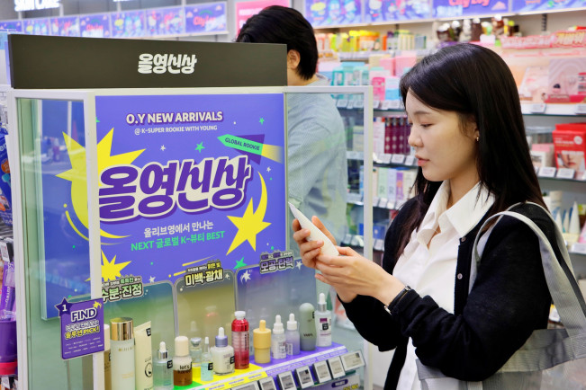 ▲올리브영 대학로중앙점 '올영신상' 매대에서 고객이 'K-슈퍼루키 위드 영' 3기 선정 브랜드 제품을 살펴보고 있다. (사진제공=CJ올리브영)