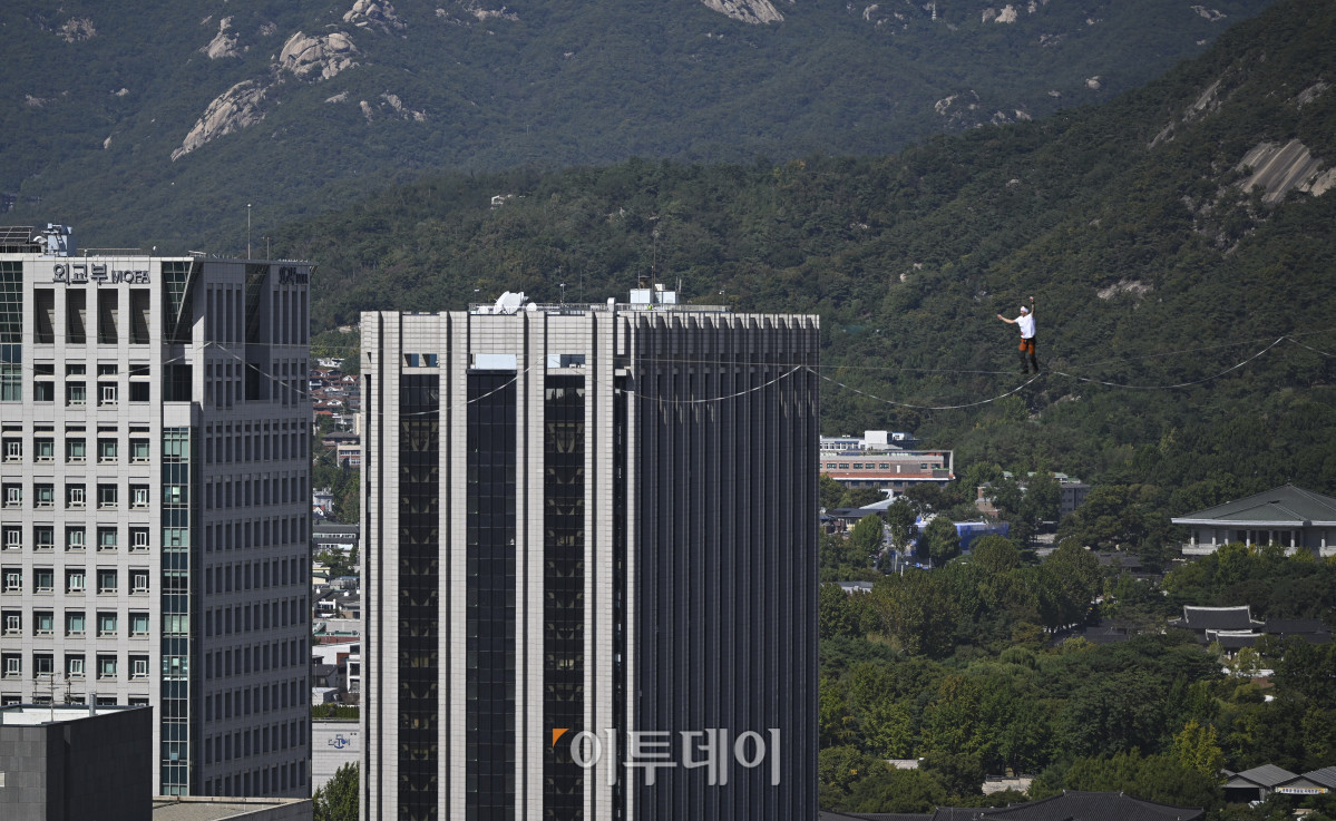 ▲에스토니아 슬랙라인 선수 얀 루스가 1일 서울 광화문 네거리 약 120m 상공에서 '레드불 서울 줄타기' 퍼포먼스를 선보이고 있다. 슬랙라인은 두 지점 사이에 설치된 좁고 평평한 줄 위에서 균형을 잡으며 이동하는 스포츠다. 이날 얀 루스는 광화문 네거리의 동아미디어센터와 코리아나호텔을 잇는 줄 위를 왕복하는 코스에 도전한다. 해당 코스는 편도 160m, 절대 고도 120m다. 고성준 기자 joonko1@