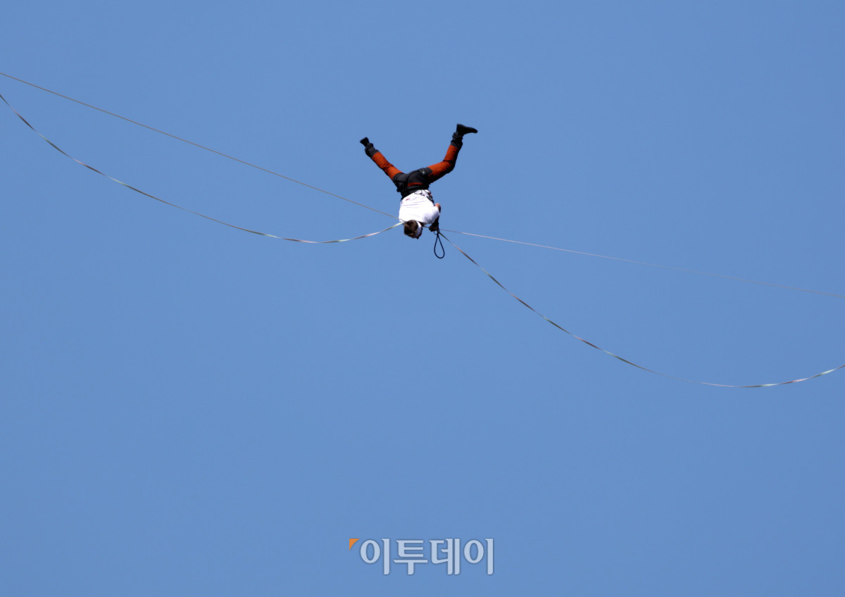▲에스토니아 슬랙라인 선수 얀 루스가 1일 서울 광화문 네거리 약 120m 상공에서 '레드불 서울 줄타기' 퍼포먼스를 선보이고 있다. 슬랙라인은 두 지점 사이에 설치된 좁고 평평한 줄 위에서 균형을 잡으며 이동하는 스포츠다. 이날 얀 루스는 광화문 네거리의 동아미디어센터와 코리아나호텔을 잇는 줄 위를 왕복하는 코스에 도전한다. 해당 코스는 편도 160m, 절대 고도 120m다. 고성준 기자 joonko1@