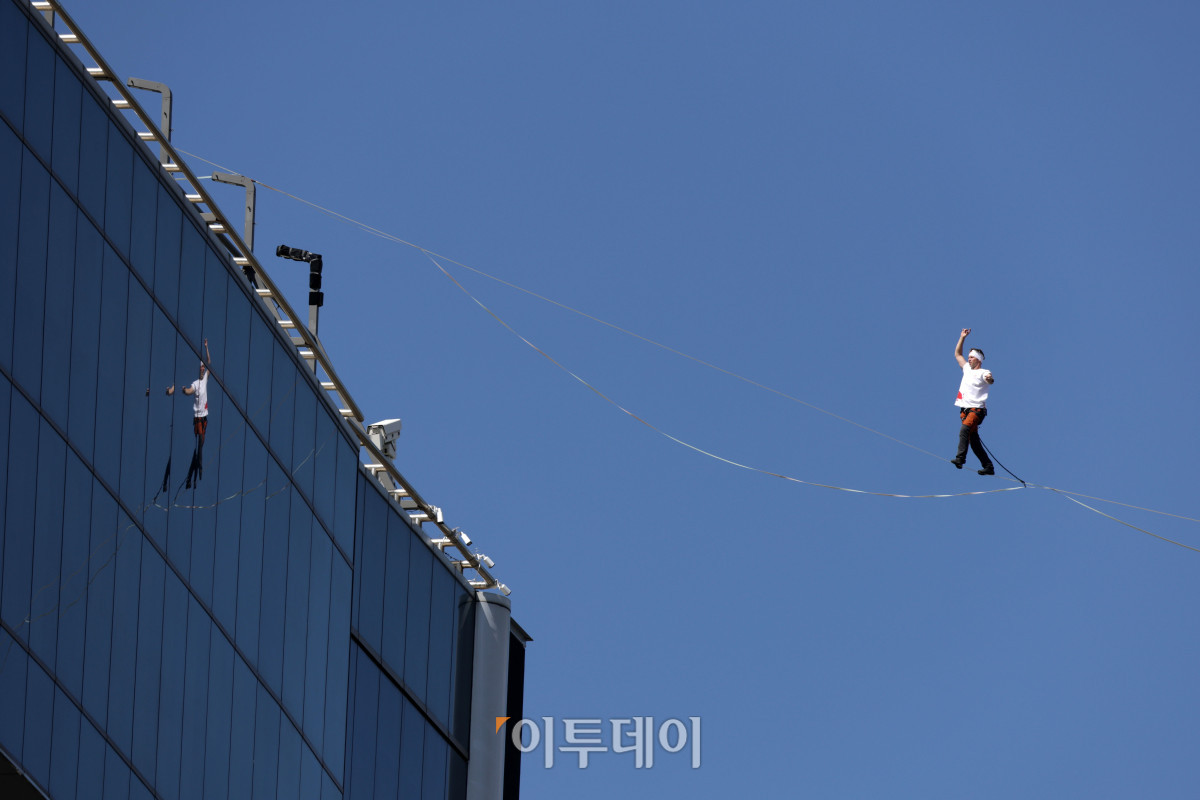 ▲에스토니아 슬랙라인 선수 얀 루스가 1일 서울 광화문 네거리 약 120m 상공에서 '레드불 서울 줄타기' 퍼포먼스를 선보이고 있다. 슬랙라인은 두 지점 사이에 설치된 좁고 평평한 줄 위에서 균형을 잡으며 이동하는 스포츠다. 이날 얀 루스는 광화문 네거리의 동아미디어센터와 코리아나호텔을 잇는 줄 위를 왕복하는 코스에 도전한다. 해당 코스는 편도 160m, 절대 고도 120m다. 고성준 기자 joonko1@