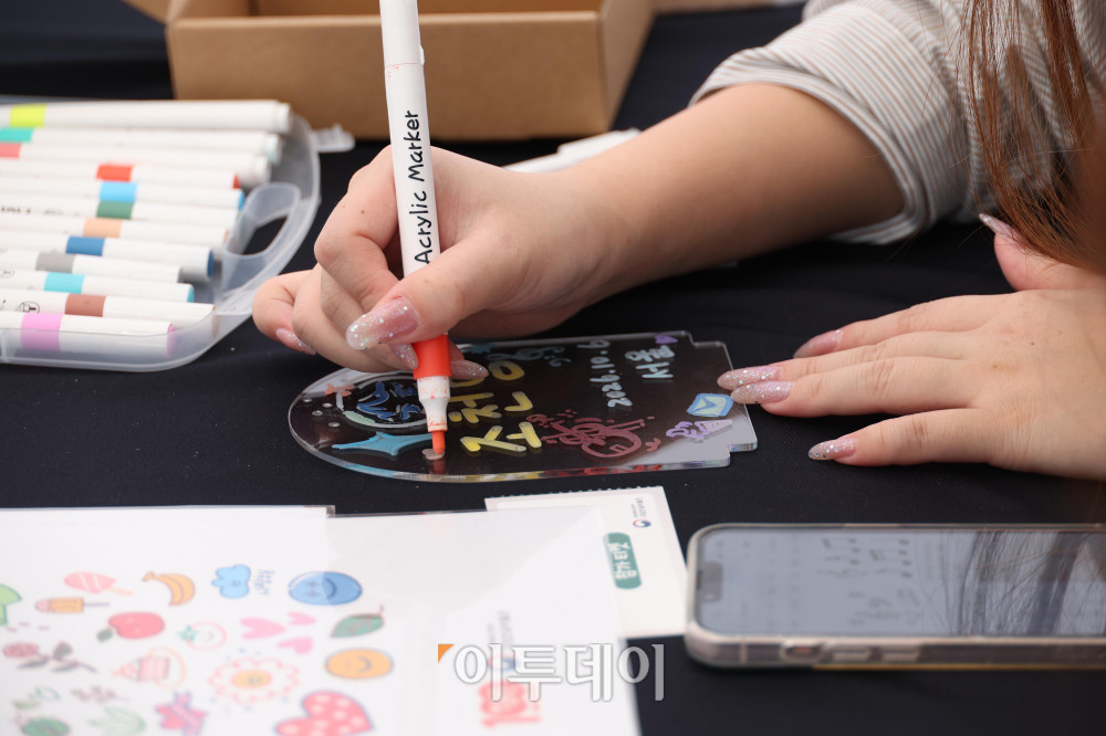 ▲한글날 100주년을 앞둔 6일 서울 광화문광장에서 열린 2026 한글문화산업전에서 외국인 관광객이 한글문화 체험을 하고 있다. ‘내 곁에 한글’을 주제로 8일까지 열리는 이번 행사에는 다양한 한글문화상품과 콘텐츠를 전시·판매하고 체험 공간을 운영한다. 고이란 기자 photoeran@