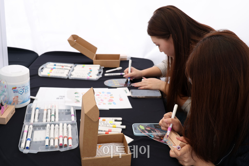 ▲한글날 100주년을 앞둔 6일 서울 광화문광장에서 열린 2026 한글문화산업전에서 외국인 관광객이 한글문화 체험을 하고 있다. ‘내 곁에 한글’을 주제로 8일까지 열리는 이번 행사에는 다양한 한글문화상품과 콘텐츠를 전시·판매하고 체험 공간을 운영한다. 고이란 기자 photoeran@