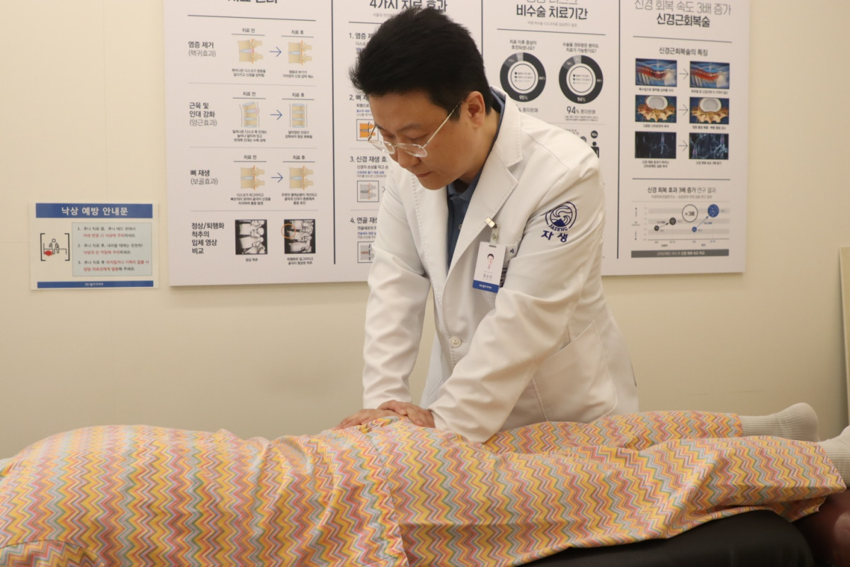 ▲홍순성 자생한방병원장이 강직성 척추염을 앓고 있는 환자에게 추나요법 치료를 하고 있다.