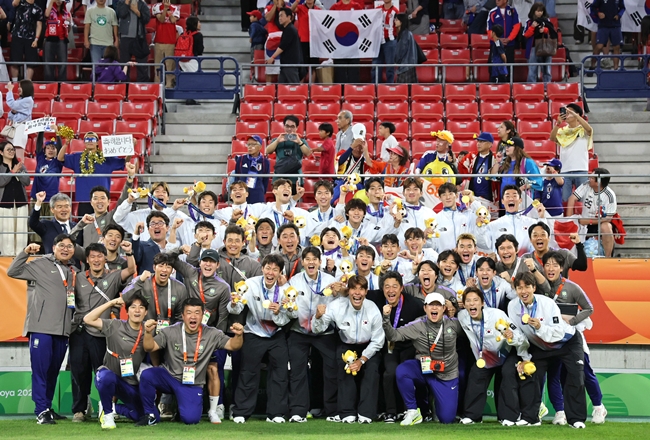 ▲3일 일본 아이치현 도요타 스타디움에서 열린 2026 아이치·나고야 아시안게임 남자 축구 시상식에서 금메달을 획득한 한국 대표팀 선수들이 이민성 감독을 비롯한 코칭 스태프들과 기념촬영을 하고 있다. (연합뉴스)