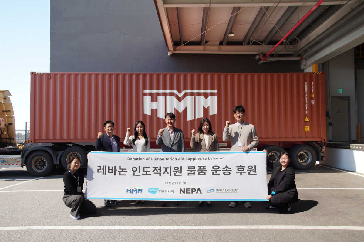 ▲6일 경기도 평택시 네파(NEPA) 스마트 물류센터에서 진행된 ‘레바논 인도적지원 물품 운송 후원’ 상차식에서 관계자들이 기념 촬영을 하고 있다. (사진=HMM)