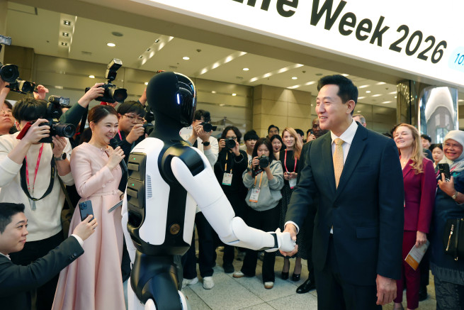 ▲오세훈 서울시장이 8일 코엑스에서 열린 SLW 2026 전시장 입구에서 로봇과 악수하고 있다. (사진제공=서울시)