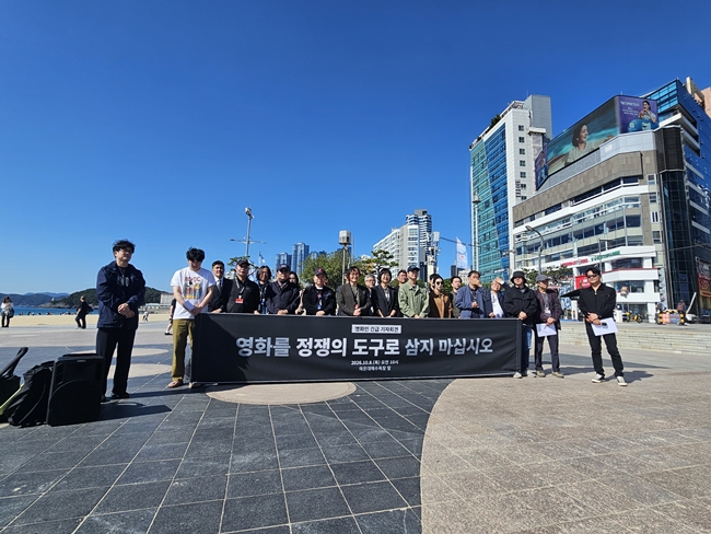 ▲8일 오전 부산 해운대 이벤트광장에서 열린 영화인 긴급 기자회견에서 참석 영화인들이 “영화를 정쟁의 도구로 삼지 마십시오”라고 적힌 현수막 앞에서 공동입장을 발표하고 있다. (사진제공=영화인연대)